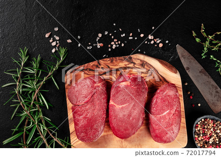 Gourmet meat. Beef steaks on a cutting board with seasoning and copy space 72017794