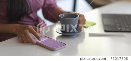 Female using smartphone while take a coffee break in meeting room Female using smartphone while take a coffee break in meeting room 72017808
