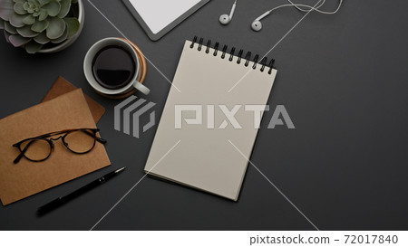 Worktable with blank notebook, coffee cup, glasses, supplies and copy space on the table Worktable with blank notebook, coffee cup, glasses, supplies and copy space on the table 72017840