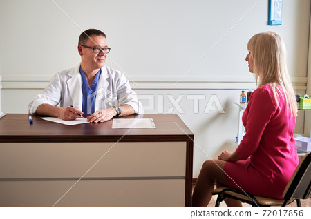 Blonde young woman having consultation with doctor in clinic. Blonde young woman having consultation with doctor in clinic. 72017856