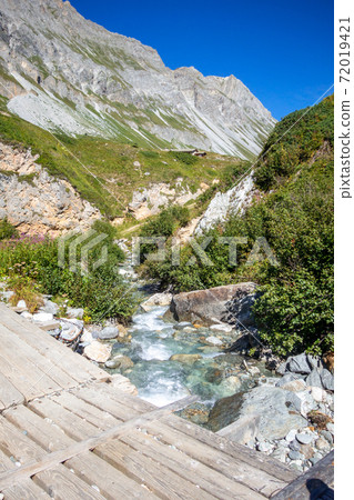 Mountain river and wood bridge in Vanoise national Park valley, French alps 72019421