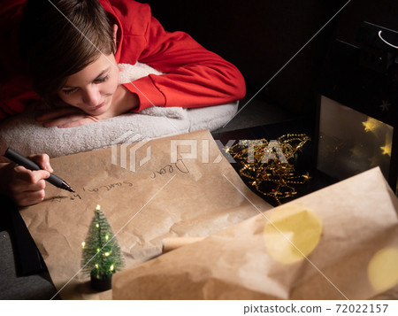 Teenage boy writing long letter to Santa 72022157
