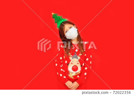 Girl in a red Christmas sweater during the quarantine period 72022356