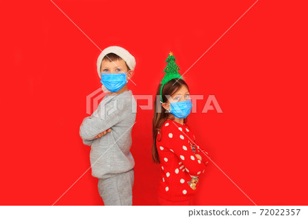 A boy and a girl wearing respiratory masks keep their distance 72022357