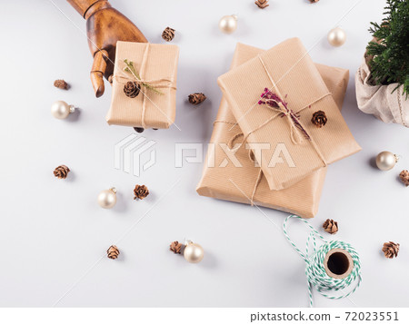 Wrapped xmas gifts and ornament in hand 72023551
