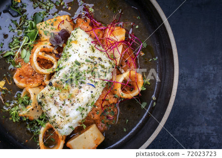 Traditional braised cod fish filet with lettuce and calamarata noodles Traditional braised cod fish filet with lettuce and calamarata noodles 72023723