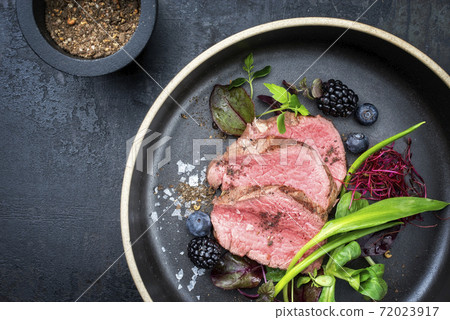 Traditional barbecue dry aged sliced fillet steak with wild garlic and fruits  72023917