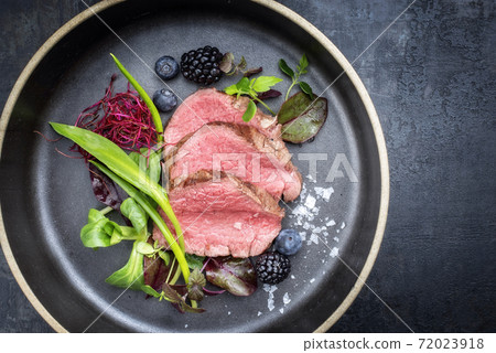 Traditional barbecue dry aged sliced fillet steak with wild garlic and fruits  72023918
