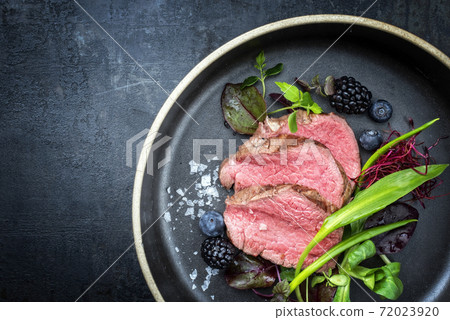 Traditional barbecue dry aged sliced fillet steak with wild garlic and fruits  72023920