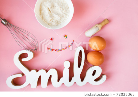 Ingredients for cooking baking - flour, egg, sugar, rolling pin on pink background. Concept of cooking dessert 72025363