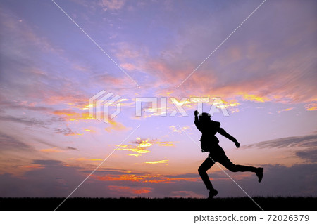 Silhouette, effort, competition, speed image of a businessman running vigorously against the backdrop of the setting sun 72026379
