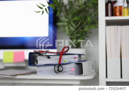 In medical office there is stethoscope on documents. 72026407