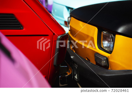 Two small cars of different colors on the road 72028461