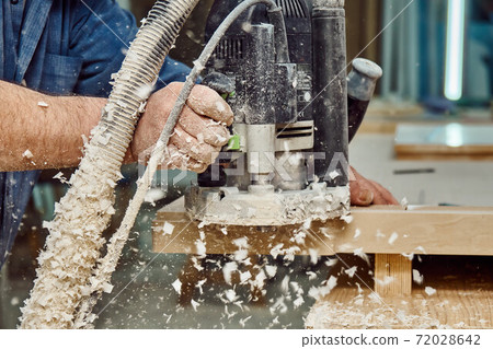 Carpenter with hand electric router machine at work. Milling process of acrylic kitchen countertop Carpenter with hand electric router machine at work. Milling process of acrylic kitchen countertop 72028642