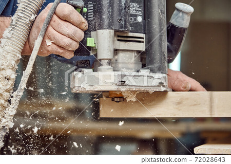 Carpenter with hand electric router machine at work. Milling process of acrylic kitchen countertop Carpenter with hand electric router machine at work. Milling process of acrylic kitchen countertop 72028643