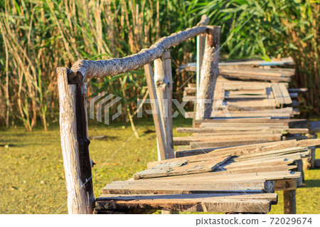 Old wooden bridge over the small river. Old wooden bridge over the small river. 72029674