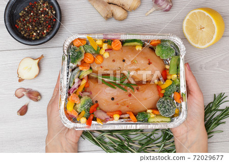 Raw chicken breasts or fillet in metal container with ingredients. Raw chicken breasts or fillet in metal container with ingredients. 72029677