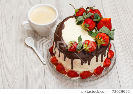 Homemade chocolate cake decorated with fresh strawberries on glass plate and cup of coffee Homemade chocolate cake decorated with fresh strawberries on glass plate and cup of coffee 72029693