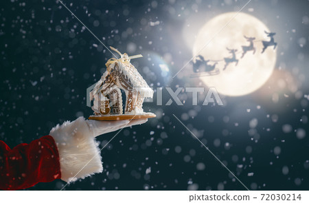 Gingerbread house in the hand. Gingerbread house in the hand. 72030214