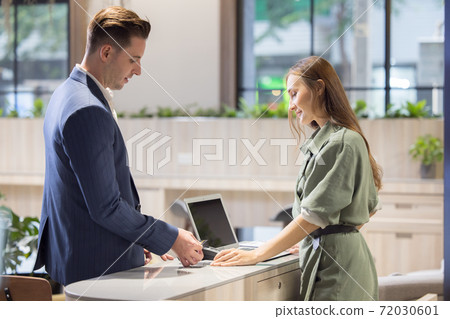 Receptionist Taking Payment With Credit Card, Charge it to my current account at counter in hotel Receptionist Taking Payment With Credit Card, Charge it to my current account at counter in hotel 72030601