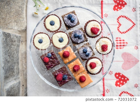 Top view of selection of colorful and delicious cake desserts on tray on table. 72031072