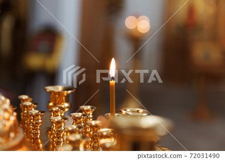Orthodox Church. Christianity. Festive interior decoration with burning candles and icon in traditional Orthodox Church on Easter Eve or Christmas. Religion faith pray symbol. 72031490