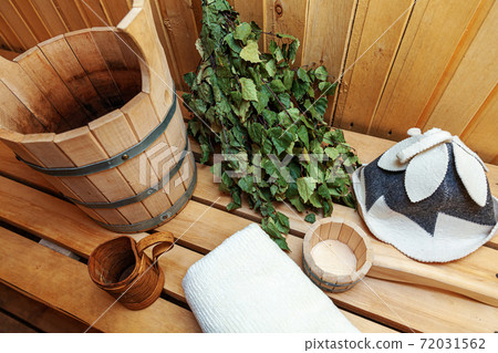 Interior details Finnish sauna steam room with traditional sauna accessories basin birch broom scoop felt hat towel. Traditional old Russian bathhouse SPA Concept. Relax country village bath concept. 72031562