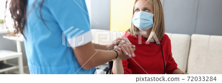 Doctor in uniform holds hand of sick young woman in wheelchair portrait Doctor in uniform holds hand of sick young woman in wheelchair portrait 72033284