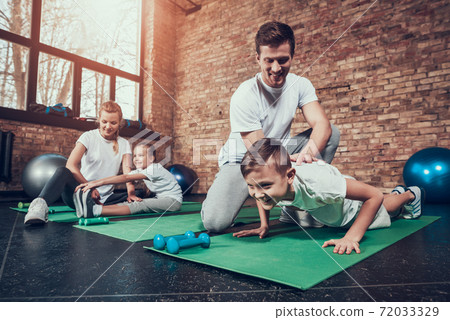 Little girl smiles and stretches her hands to feet 72033329