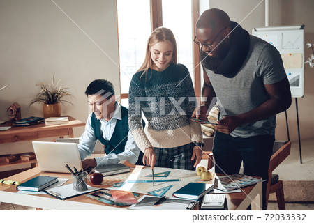 A man sits at a laptop and works in office. A man sits at a laptop and works in office. 72033332