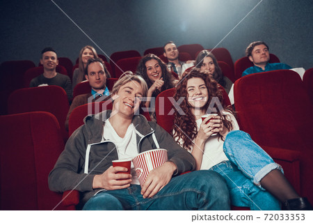 A young couple came to the cinema for a comedy. A young couple came to the cinema for a comedy. 72033353