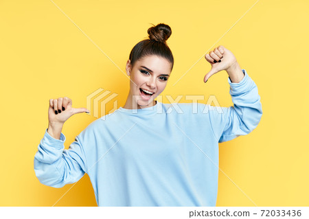 Young happy wman pointing to herself isolated over yellow background 72033436