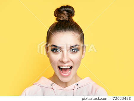Emotional suprised woman face close up portrait on yellow background. 72033458