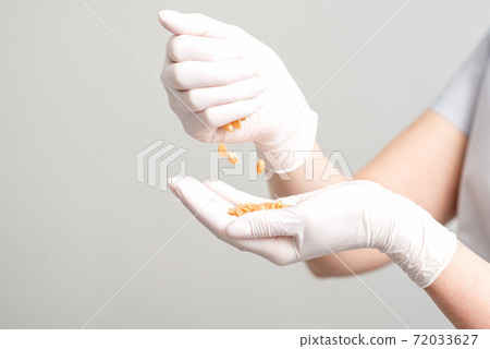 Hard wax beans in hands. 72033627