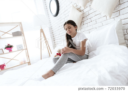 The girl has a knee pain, she is doing a massage. The girl has a knee pain, she is doing a massage. 72033970