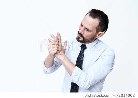 A man looks at his hand and feels severe pain. 72034008