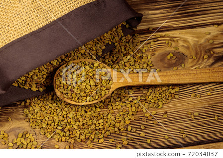 Fenugreek seeds on wooden table 72034037