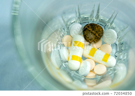 Pill and drug capsule and tablets in the glass Pill and drug capsule and tablets in the glass 72034850