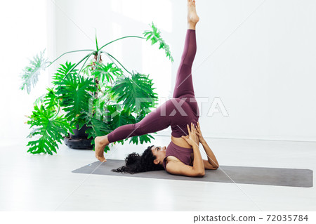 Beautiful female brunette yoga asana stretching the flexibility of the body fitness gym gym Beautiful female brunette yoga asana stretching the flexibility of the body fitness gym gym 72035784