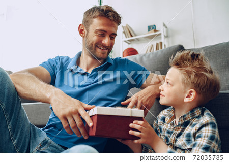 Little son gives his father a gift box for father's day Little son gives his father a gift box for father's day 72035785