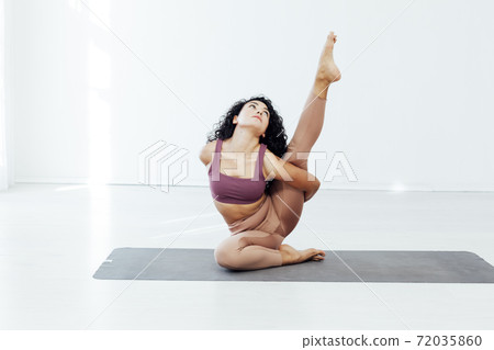 Beautiful woman brunette yoga asana stretching the flexibility of the body fitness gym Beautiful woman brunette yoga asana stretching the flexibility of the body fitness gym 72035860