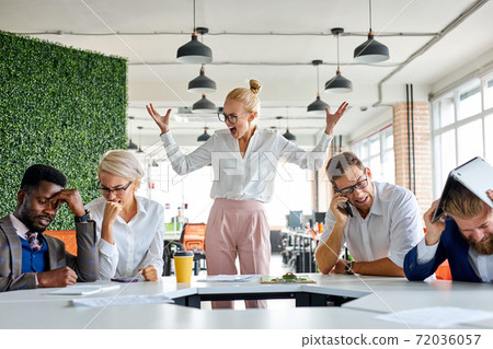 angry unbalanced female boss scream, scolds employees for not fulfilling the plan at work 72036057