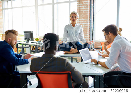 young caucasian woman meditating in office young caucasian woman meditating in office 72036068