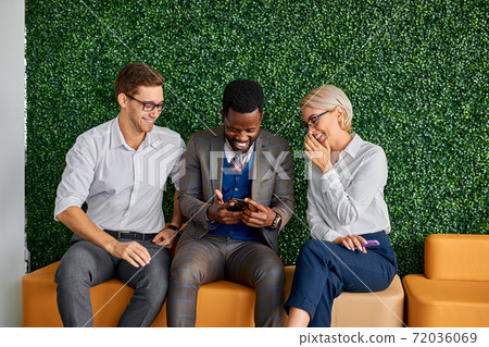 three diverse colleagues sit talking having fun three diverse colleagues sit talking having fun 72036069
