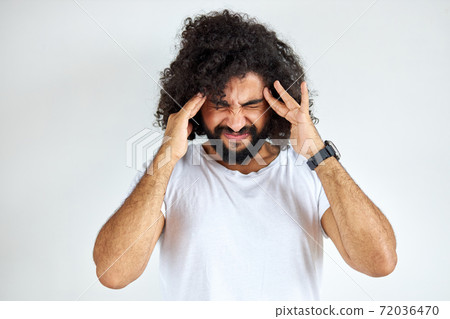 angry arabic male is having mad expressions, squeezing head with hands pissed of people around 72036470