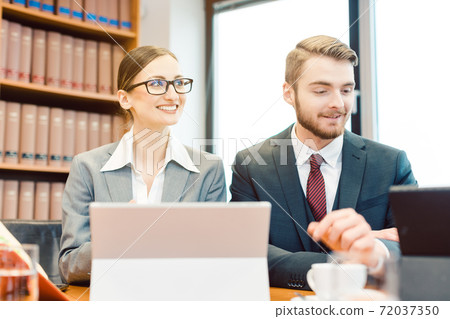 Young attorneys in law firm giving overview on case in partner meeting 72037350