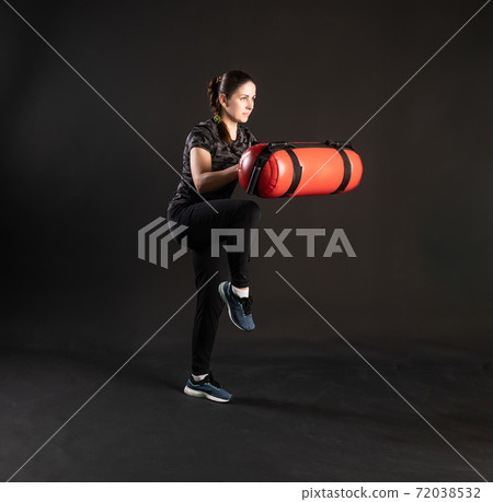 Fitness with Aqua Bag, pulls a sock, keeps the equipment. Engaged in sports on a black background Joyful with beautiful eyes 72038532
