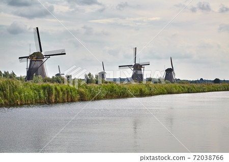 Windmill beside a canal 72038766