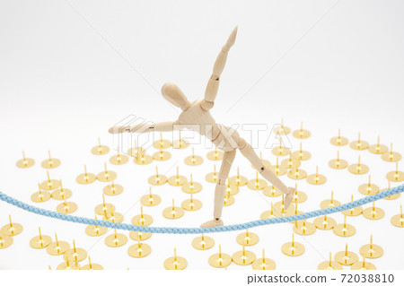 A drawing doll that walks on a tightrope while staggering on the ground where thumbtacks are sown. A drawing doll that walks on a tightrope while staggering on the ground where thumbtacks are sown. 72038810