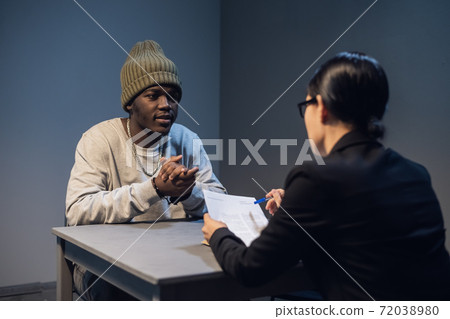 The suspect and his lawyer are considering a case management and defense strategy for appearing in court The suspect and his lawyer are considering a case management and defense strategy for appearing in court 72038980